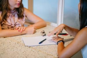 two women sitting, talking, business