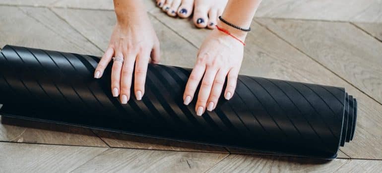 person holding yoga mat