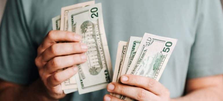 a man counting money since certain moving costs are tax deductible 