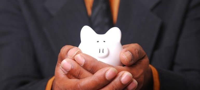 man holding a white piggy bank in his hands