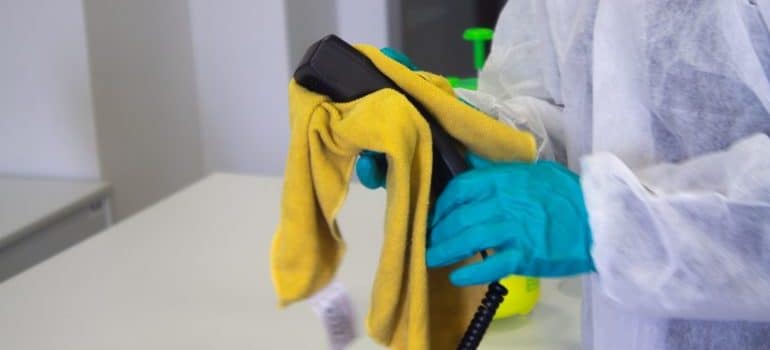 A person holding cleaning supplies 