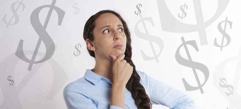 woman in a thinking pose with dollar signs floating behind her