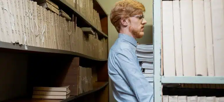 An employee moving a box with files while decluttering office for relocation
