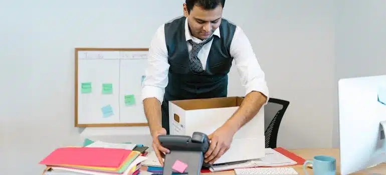 A businessman packing a box to declutter before moving his office