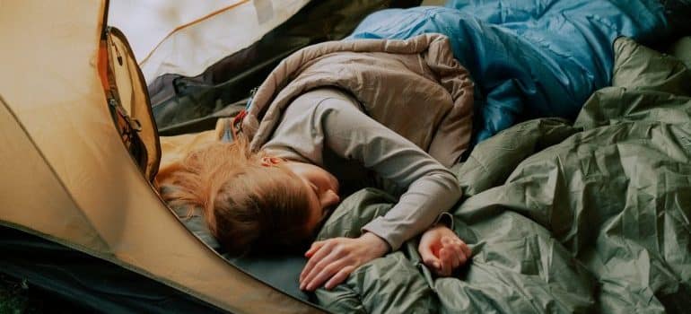 Woman sleeping in a camping sleeping bag