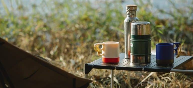 Camping mugs and thermos on a table