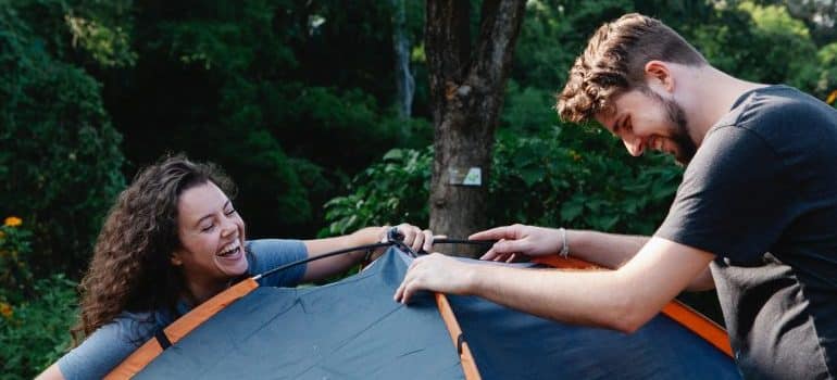 Man and woman preparing tent for packing and moving