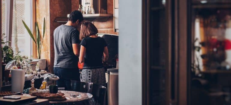 After choosing the best time to buy a house in Fort Lauderdale, a couple is in the kitchen of their home, preparing a meal.