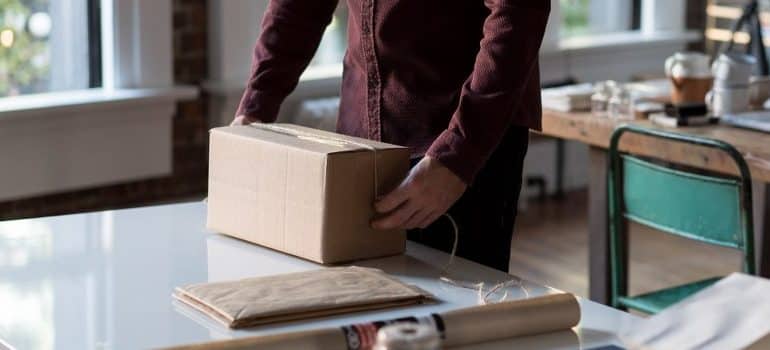 one of the white glove movers, handling a cardboard box