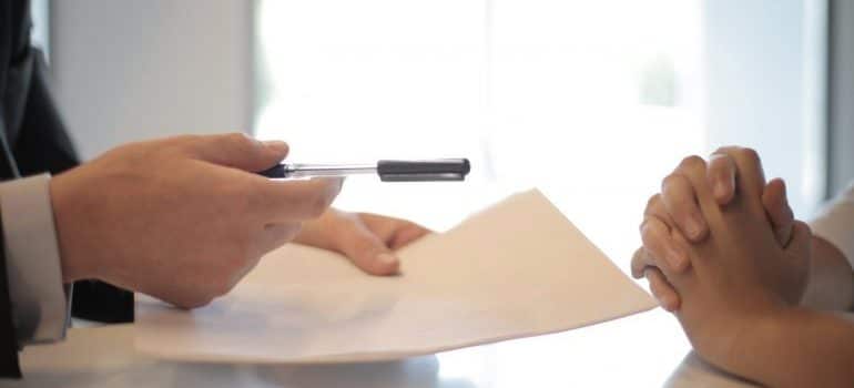 A man giving a woman contract to sign