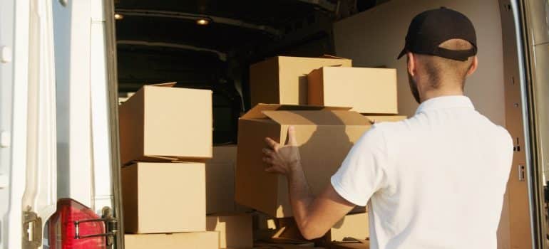 Man loading moving boxes into a truck