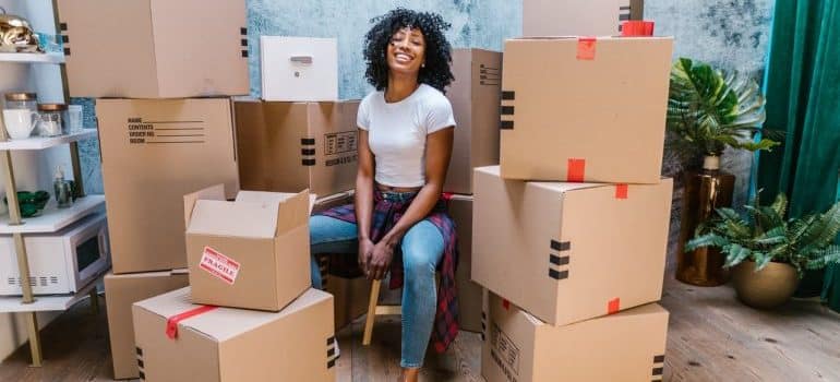 A girl sitting among moving boxes 