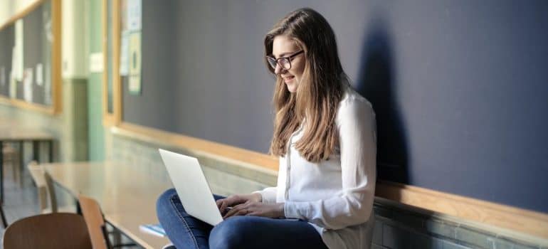 Student sitting on a bench with a laptop