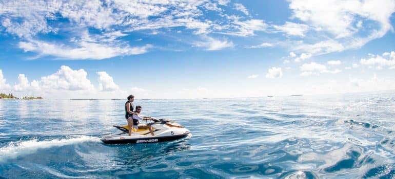 People riding jet ski on open sea 