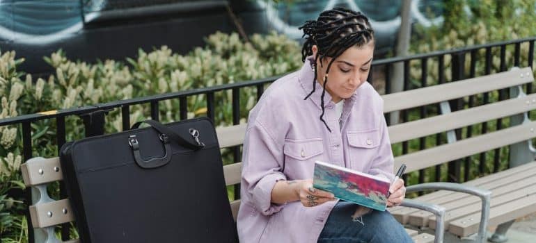 Woman sitting on a bench and writing in a notebook