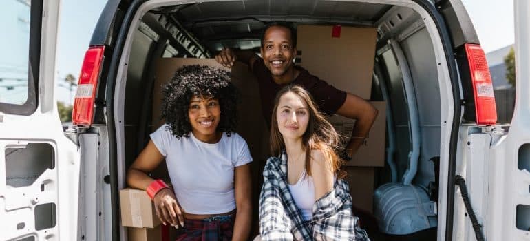 A group of friends sitting in the back of a van