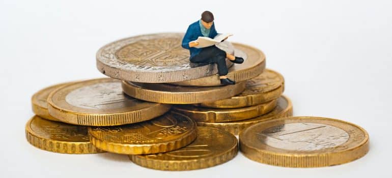 A man-looking figurine sitting on coins