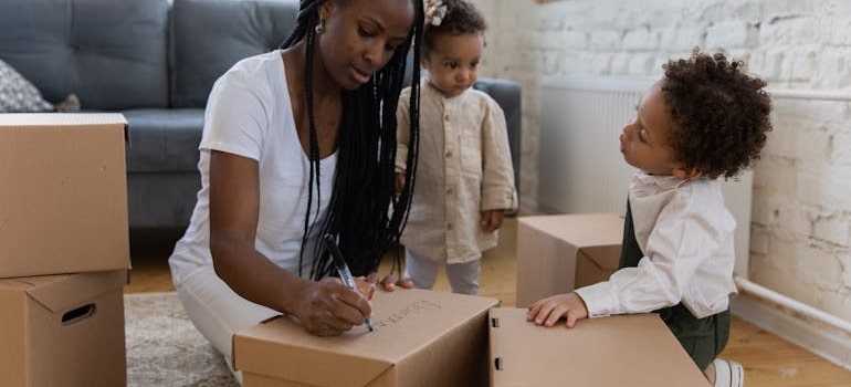 Mother and Children labeling Boxes on the floor