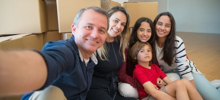 A Family Selfie while Sitting on the Floor amid boxes