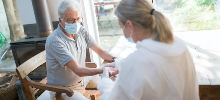 A nurse is checking an older mans' health