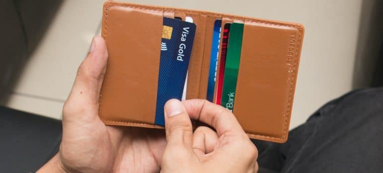 person holding credit cards and a wallet