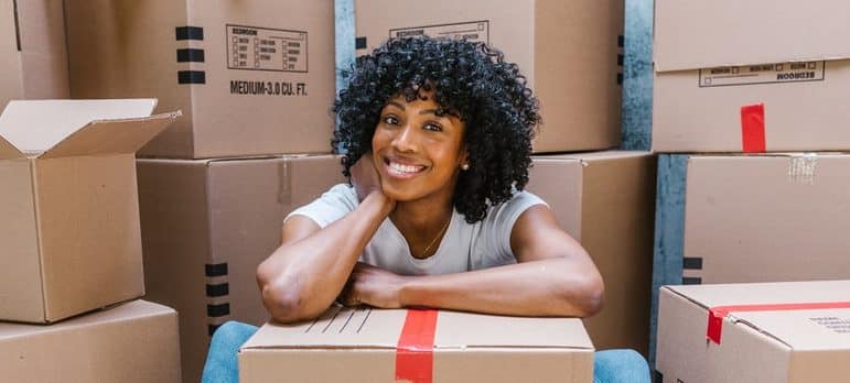 woman sitting on the floor leaning on the cardboard box