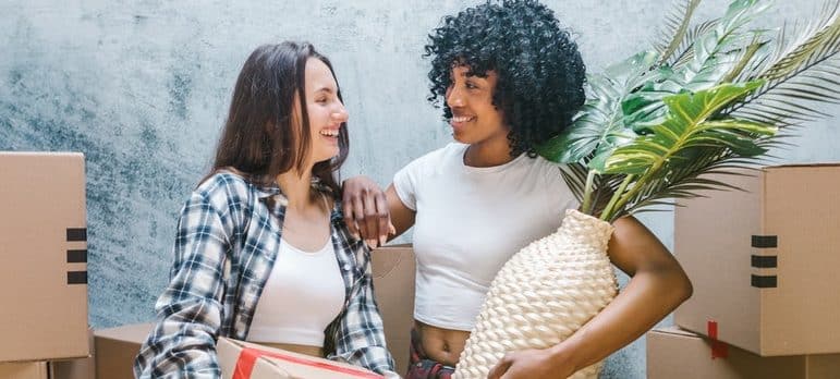 two women surrounded by moving boxes