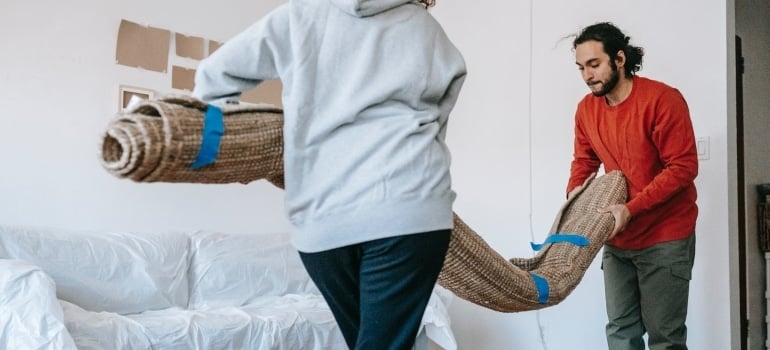 a man and a woman carrying a rug