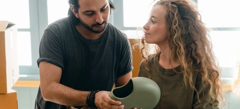 a couple trying to find the best way to pack a round porcelain item