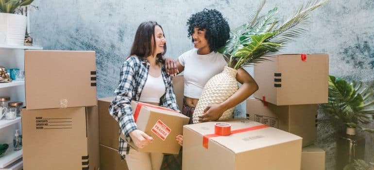 two woman holding boxes