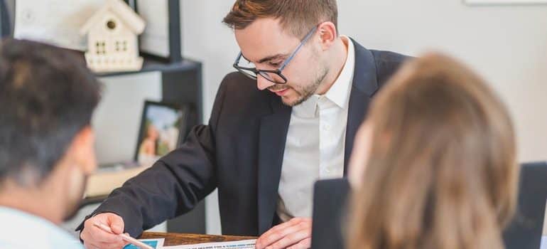 A man in a suit discussing something with his clients.