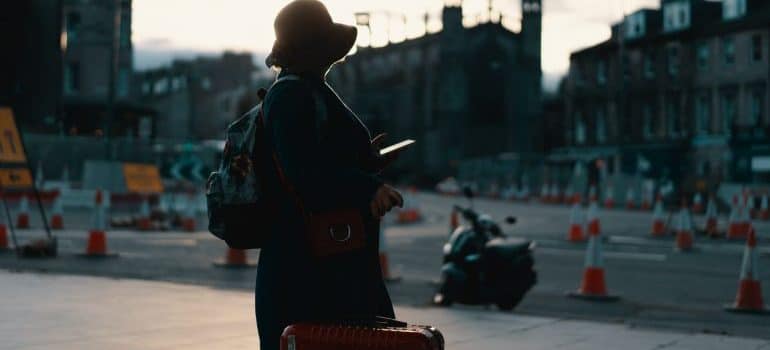 a woman with a suitcase arriving in a new city 