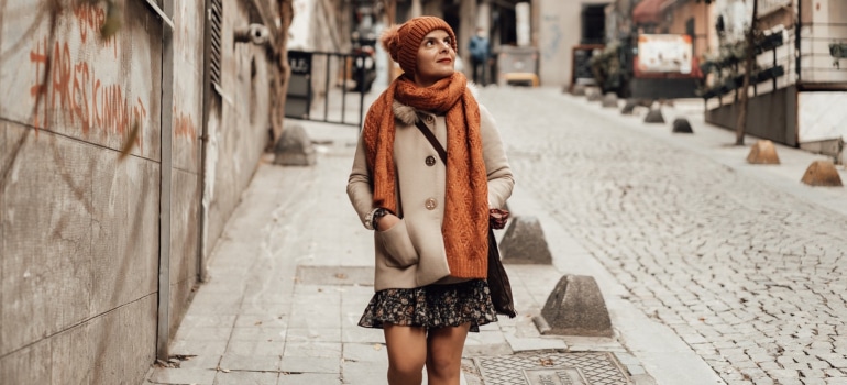 a woman looking at her surroundings as she strolls through the street