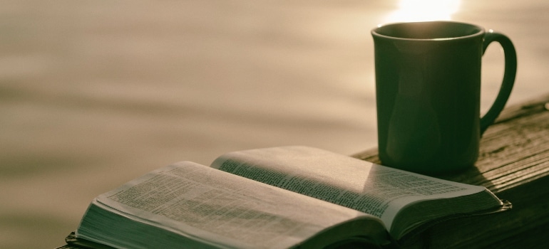 A cup of tea and an open book.