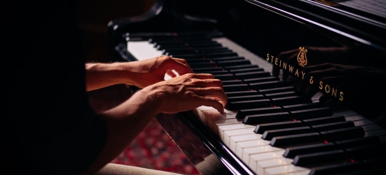 Female hands playing on piano.