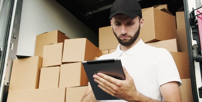 a man writing down a list of moving boxes for moving to Florida as an artist