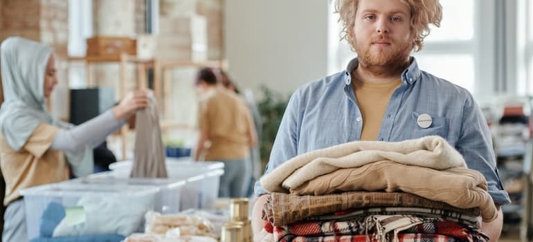 A man holding a pile of clothes