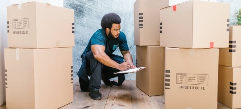 If you organize an art exhibit relocation cross country hire movers. A man checking a list.