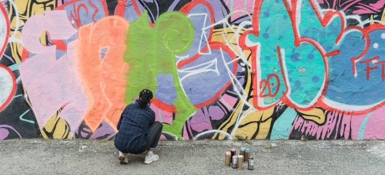 a woman painting a mural on the wall. 