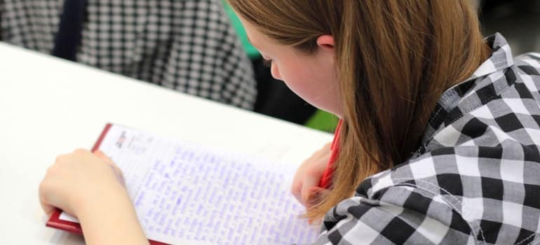 A girl is making a list on a paper.