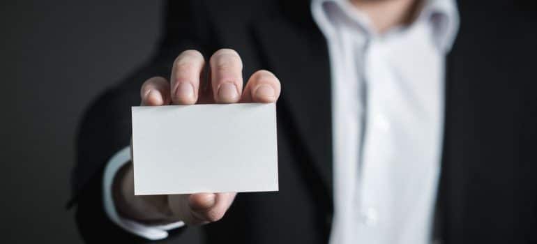 a hand holding a blank business card 