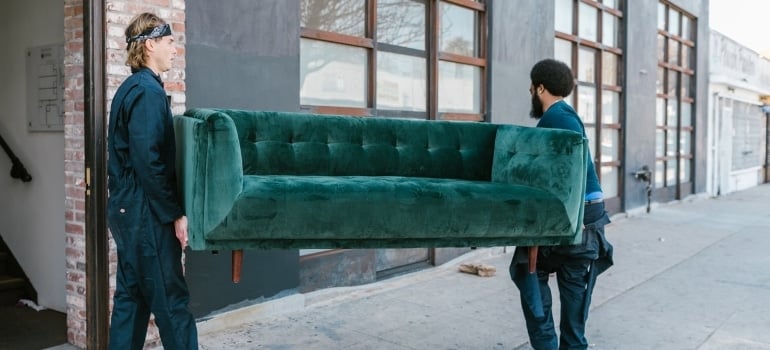 two men carrying a couch