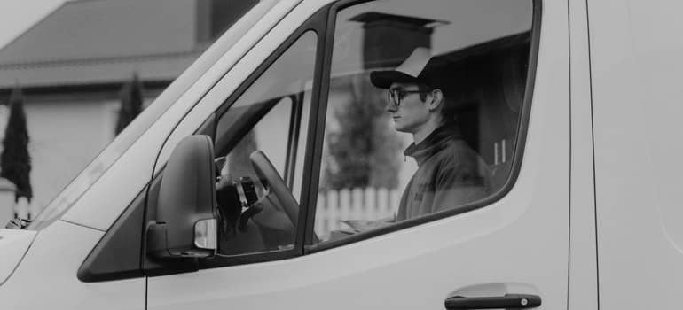 A moving van is outside of a house.