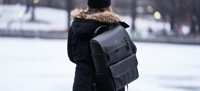 Woman wearing parka and carrying backpack during winter