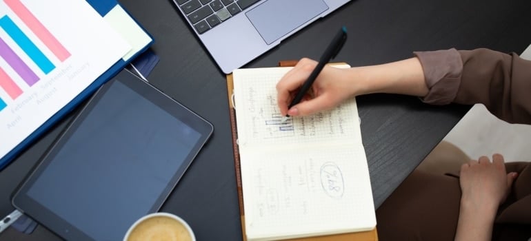 a hand writing in a notebook in an office space