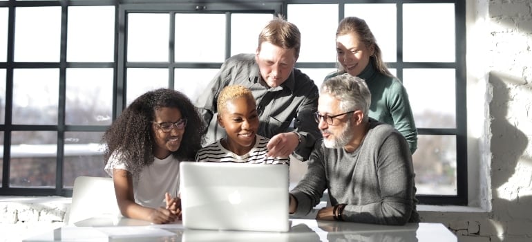 A group of people are looking at a computer