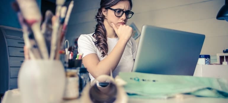 A woman is looking at a computer.