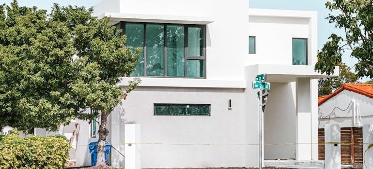 White Concrete Building Near Green Tree in one of the safest neighborhoods in Miami