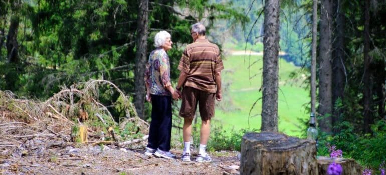 elderly couple standing in the woods