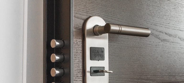 A silver lock and keyhole on a brown apartment door